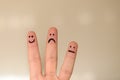 Three different emoticons hand drawn on fingers