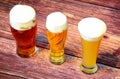 Three different glasses with three different types of light beers stand in a row on a wooden table Royalty Free Stock Photo