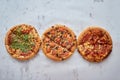 Three different kind of pizzas placed in a row on white rusty table Royalty Free Stock Photo