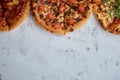 Three different kind of pizzas placed in a row on white rusty table Royalty Free Stock Photo