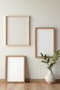 Three different sized wooden frames against a neutral wall, display, interior design, style