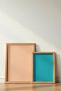 Three different sized wooden frames against a neutral wall, sizes, modern Royalty Free Stock Photo