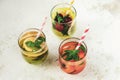 Three different summer healthy drinks, lemonade in glasses with straw on white background. Top view Royalty Free Stock Photo