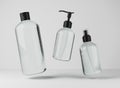 Three different transparent glass bottles for hair and body care products 3D render, set of floating cosmetic containers Royalty Free Stock Photo