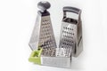 Three different types of vegetable graters in size and shape, with different handles on a blom background,