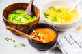 Three different vegetable cream soups in bowls on gray background. Corn, cucumber and gazpacho soups Royalty Free Stock Photo