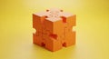 3D Rendered Orange Puzzle Cube Assembled from Interlocking Pieces on a Yellow Background image photo Royalty Free Stock Photo