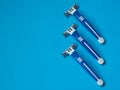 Three disposable razors on a blue background Royalty Free Stock Photo