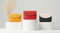 Stylish leather wallets in vibrant colors displayed on white pedestals against a minimalist background Royalty Free Stock Photo