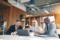 Three diverse businesspeople laughing while working together in Royalty Free Stock Photo