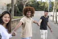 Three diverse and confident friends holding hands together. Multiracial group of people smiling and holding hands in a