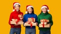 Three Diverse Girls Holding Xmas Gifts Standing, Yellow Background, Panorama Royalty Free Stock Photo