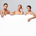 Three Diverse Models Posing Behind White Board On Gray Background