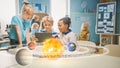 Three Diverse School Children in Science Class Use Digital Tablet Computer with Augmented Reality