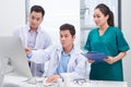 Three doctors discussing patient files on office