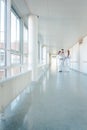 Three doctors on hospital corridor having short meeting Royalty Free Stock Photo