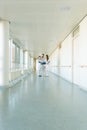 Three doctors on hospital corridor having short meeting Royalty Free Stock Photo