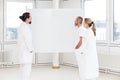 Three doctors looking to a empty whiteboard, concept medicine and healthcare