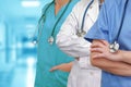 Three Doctors with stethoscope in standing on blurred green background of hospital hall Royalty Free Stock Photo
