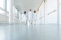 Three doctors walking down a corridor in hospital Royalty Free Stock Photo