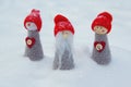 Three dolls gnome in red caps on the background of snow Royalty Free Stock Photo