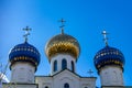 Three domes of a church with crosses against a blue sky.