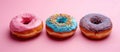 Three Donuts With Sprinkles on a Pink Background Royalty Free Stock Photo