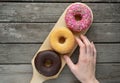 Three donuts on a wooden board background with blank space