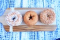 Three donuts on wooden cutting board