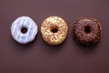 three doughnuts isolated on brown background Royalty Free Stock Photo