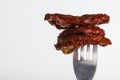 Three dried tomatoes impaled on fork