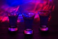 Three drinks at the party. Three shots with cocktails at the bar. Liquor, vodka, fresh. Shining on a colored background. Night clu