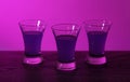 Three drinks at the party. Three shots with cocktails at the bar. Liquor, vodka, fresh. Shining on a colored background. Night