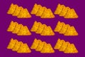 Three each bitten nachos on violet color background