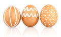 Natural isolated eggs. Three Easter brown eggs decorated with patterns of white paint Royalty Free Stock Photo