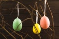 Three Easter eggs with branches on dark wooden background Royalty Free Stock Photo