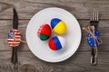 Three Easter eggs painted in the color of the flags of Russia, Ukraine and Belarus in a plate on a wooden table Royalty Free Stock Photo