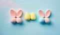 three easter eggs and three bunny ears on a blue background with copy space for text or image, top view, flat lay, with copy Royalty Free Stock Photo