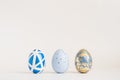 Three Easter golden decorated eggs on blue background. Minimal easter concept. Happy Easter card with copy space for