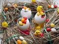 Three egg shells in a cup filled with colorful coated eggs Royalty Free Stock Photo