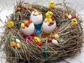 Three egg shells in a cup filled with colorful coated eggs