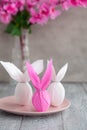 Three eggs bunny in a colored paper wrapper on a plate, nearby branch of cherry blossoms. The Easter holiday Royalty Free Stock Photo