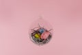 Three eggs in a floating glass nest. Pink background. Creative Easter concept