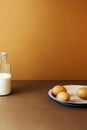 Three eggs with milk in glass bottle on brown background Royalty Free Stock Photo
