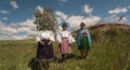 Three elderly indigenous women from Cayambe walking through the countryside during the day