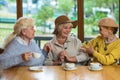 Three elderly ladies drinking coffee.