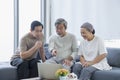 Three elderly people are using laptop computers. Group of seniors talking in the living room Royalty Free Stock Photo