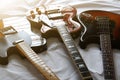 Three electric guitars placed on a white cloth, macro abstract