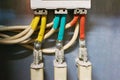 Three electrical high-voltage fuses connected to the colored wires. Industrial background. Royalty Free Stock Photo