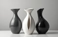 Three elegant sculpted ceramic vases in black white, grey tones displayed on white surface. Modern abstract art forms with smooth Royalty Free Stock Photo